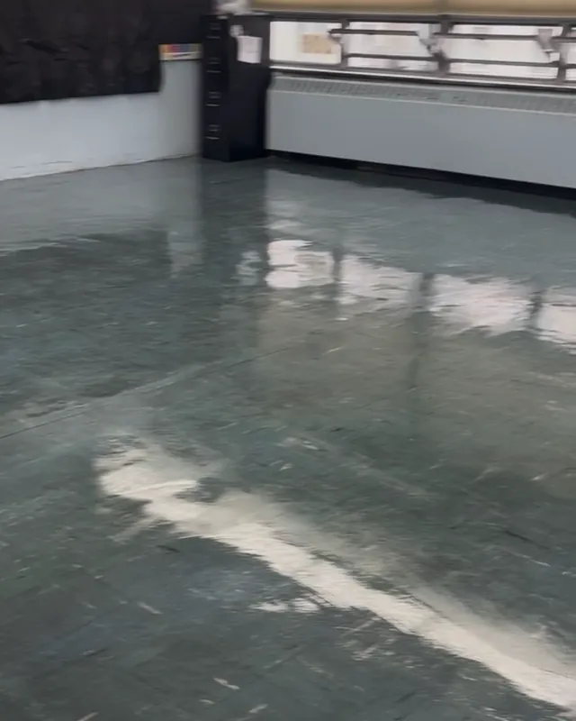 After: the same classroom floor clean and waxed, the tile glossy enough to reflect the windows.